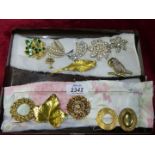 Eleven brooches including ivy leaf, parrot, flowers, leaves etc. and two scarf clips.