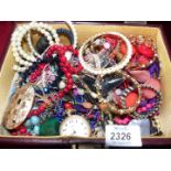 A burgundy jewellery box of costume jewellery including chunky bangles and necklaces.