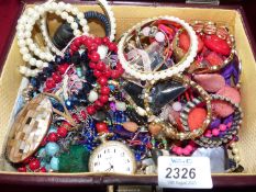 A burgundy jewellery box of costume jewellery including chunky bangles and necklaces.