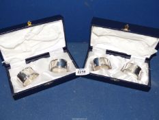 Two pairs of 800 silver napkin rings in presentation boxes.