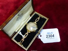 A 9ct gold wristwatch with hinged back, expanding bracelet marked 'Britannic Patent 210744 9ct,