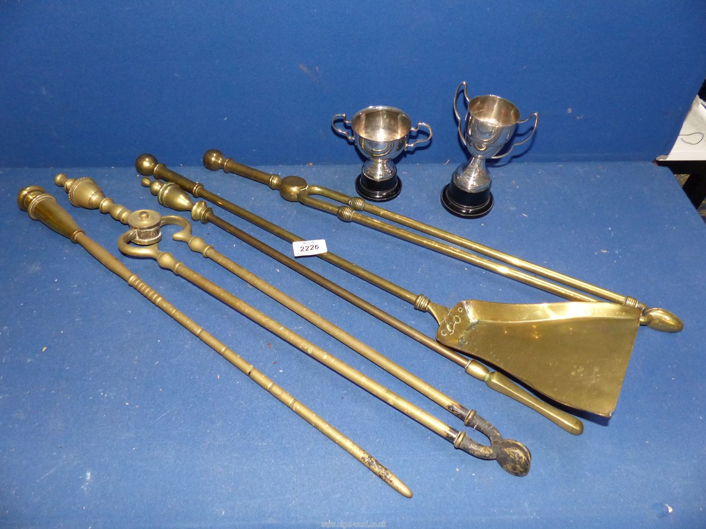 A quantity of brass Fire Irons and two plated trophies.