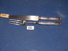 A French metal carving knife and fork set marked Paris to blade.
