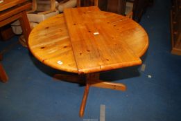 An extending Honey Pine kitchen table - 42" diameter x 20" high plus leaf extension.