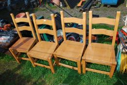 Four wooden dining chairs.