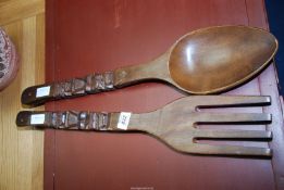 A large carved spoon and fork wall art.