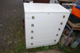 A white five drawer chest.