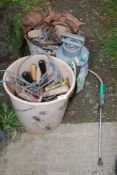 A small garden sprayer, bucket of nails and a bucket of garden tools.
