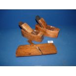 Two small antique wood block planes and an antique wooden moulding plane.