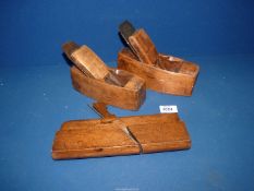 Two small antique wood block planes and an antique wooden moulding plane.