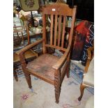 An Oak framed open armed Elbow Chair having a relief patterned leather seat,