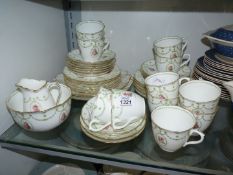 A Royal Doulton 12 person tea service with green swags and rose panels, one cup missing.