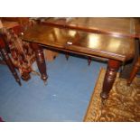 An Edwardian Mahogany windout Dining Table standing on turned and reeded legs terminating with