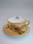 A Royal Worcester blush ivory cup and saucer, painted flowers and leaves gilt, uneven rim,