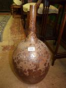 A brown long necked vase having interesting mottled glaze, 21 1/2" tall.