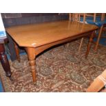 A Satinwood centre Table having canted corners and raised on turned legs,