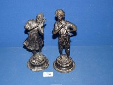 A pair of early 20th century continental bronze figures of a boy and girl playing musical