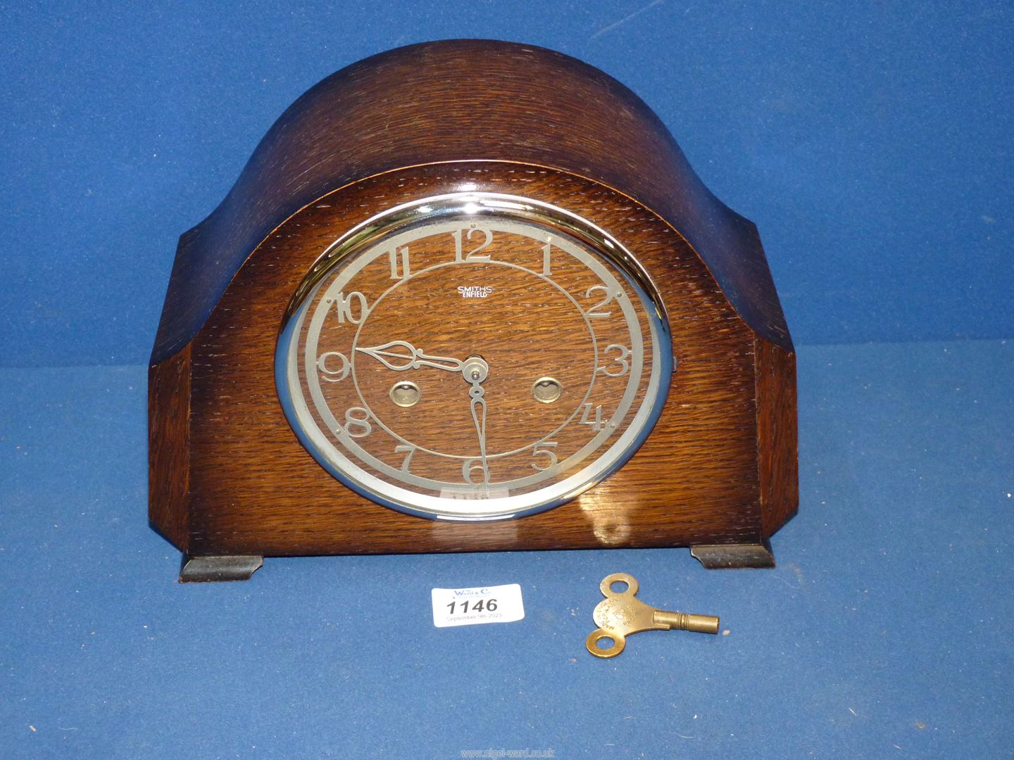 A darkwood 'Smith Enfield' Clock with key, 11" wide x 8" high x 4" deep.