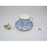 A Royal Worcester cup and saucer in blue ivy leaf pattern on cream ground and a miniature Royal