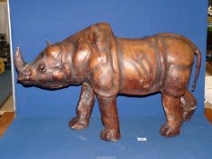 A large leather covered Rhinoceros, in need of some attention, 35'' x 20 1/2''.