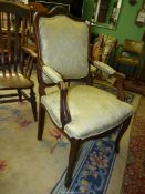 An Oak framed open armed Armchair standing on cabriole front legs and having elegant splayed arm