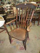 A solid Elm seated Grandfather's Armchair having turned legs, stretchers and arm supports.