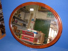 A Mahogany framed oval wall Mirror, 27" x 22".