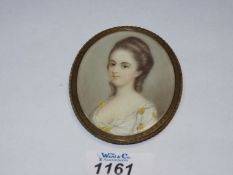 An oval framed Watercolour portrait (possibly painted on glass) depicting a young lady in a white