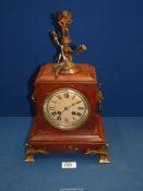 A two train movement red marble mantle Clock having Roman numerals with mask handles to the side,