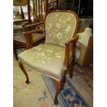 An elegant Walnut framed open armed Armchair standing on front cabriole legs,