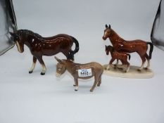 A Beswick grey donkey together with two other ceramic horse figures.
