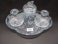 A four piece dressing table set in pale blue glass.