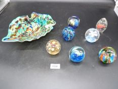 Seven paperweights and a multicoloured glass dish.
