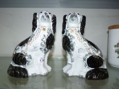 A pair of Staffordshire mantle Spaniels white with black patches having gold chains and padlocks,