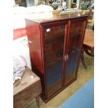 A contemporary dark Mahogany finished floor-standing Display Cabinet having a plinth type base,