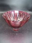 A heavy ruby crystal tapered bowl with raised rounded interior ribs and a deep clear base,