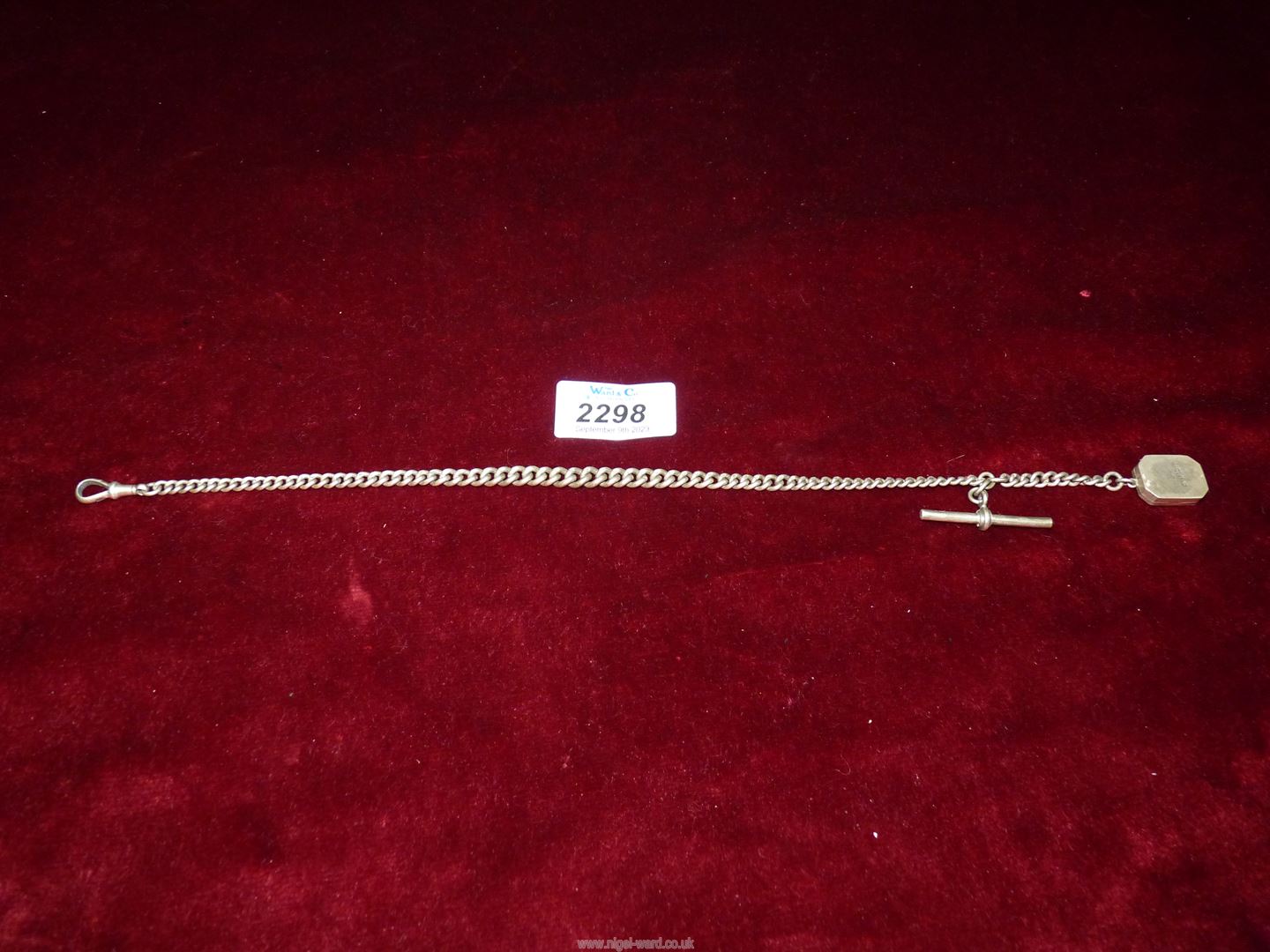 A Silver 'T' bar pocket watch Chain with a silver double locket,