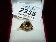A gold ring with central red stone (garnet??**) surrounded by pearls, hallmarks indistinct.