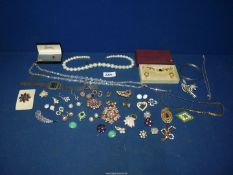 A quantity of costume jewellery including necklaces, brooches, clip-on earrings etc.