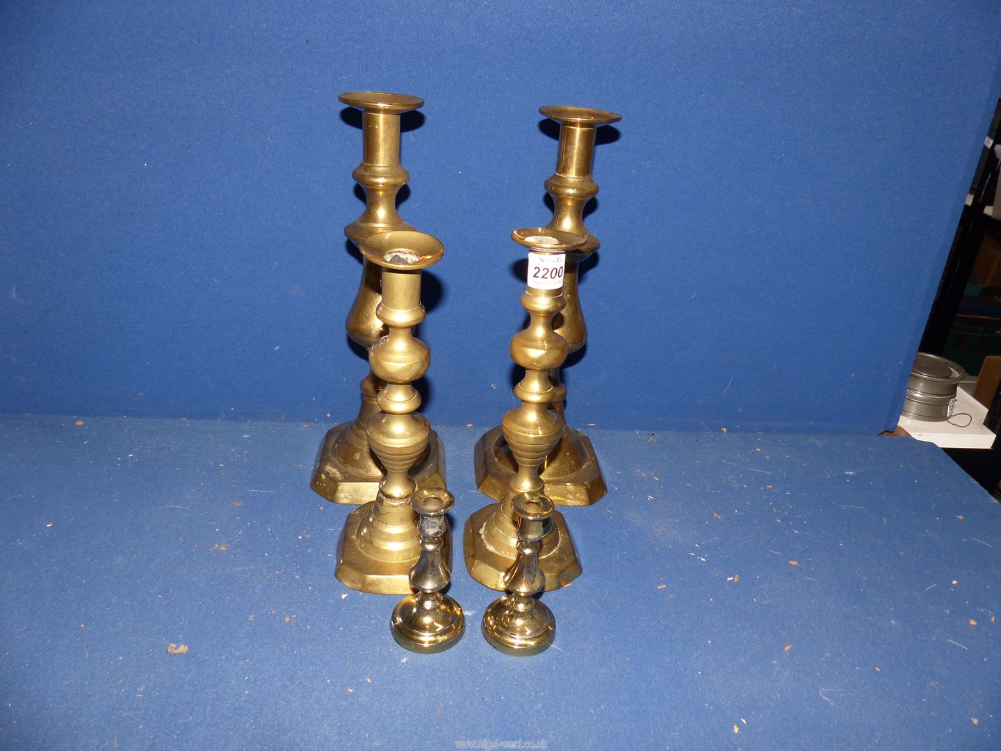 Three pairs of brass candlesticks, some with pushers.