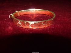 A Birmingham 9ct gold, yellow gold half engraved hinged bangle with safety chains (damaged),
