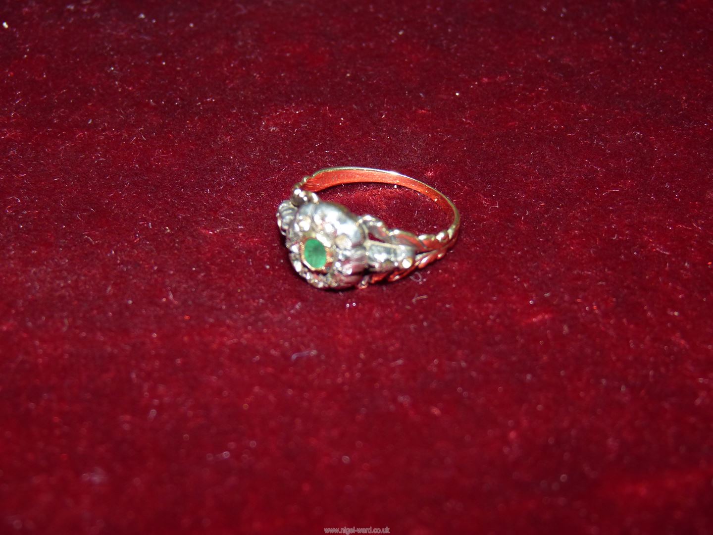 A pretty Georgian diamond and emerald ring - the small lozenge shaped emerald surrounded with rose