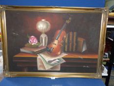 A large framed Oil on canvas depicting a Still Life with a desk, violin, books and music sheets,