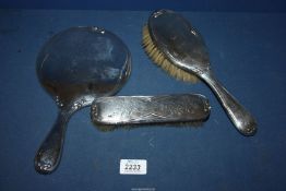 A Silver backed hand mirror, hair and clothes brush, Birmingham 1907, makers Sothers, Orchard & Co.