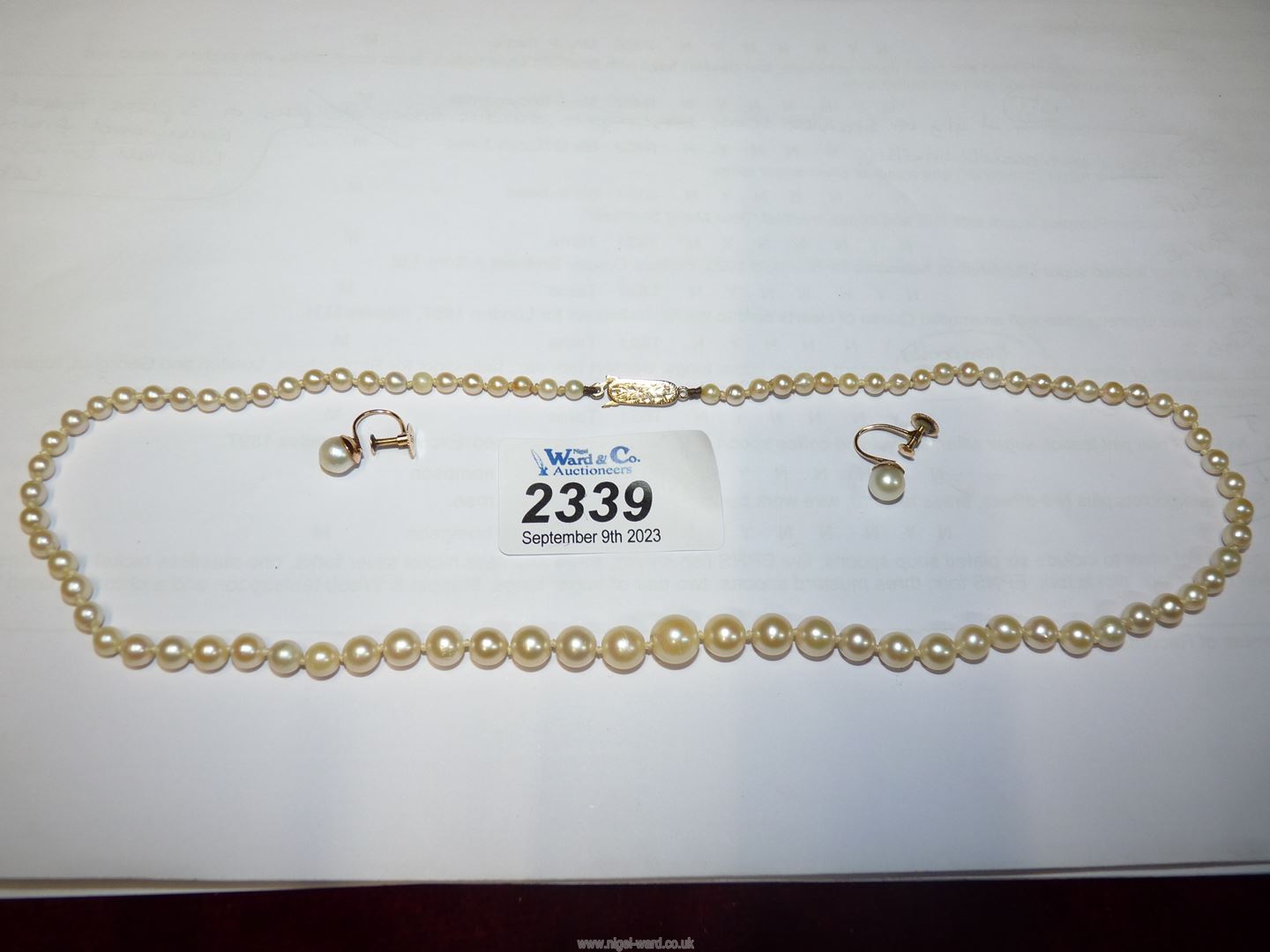A cultured pearl necklace and a pair of screw back earrings with 9ct gold clasp and backs.