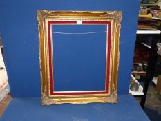 A gilt coloured picture frame with red velvet strip, aperture size 16" x 20",
