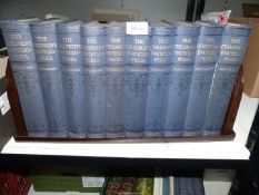 Ten volumes of The Children's Encyclopedia on a Bakelite book stand.