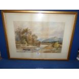 A framed and mounted Watercolour depicting a river landscape and hills in the distance,