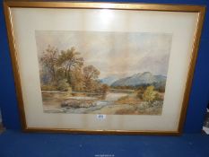 A framed and mounted Watercolour depicting a river landscape and hills in the distance,