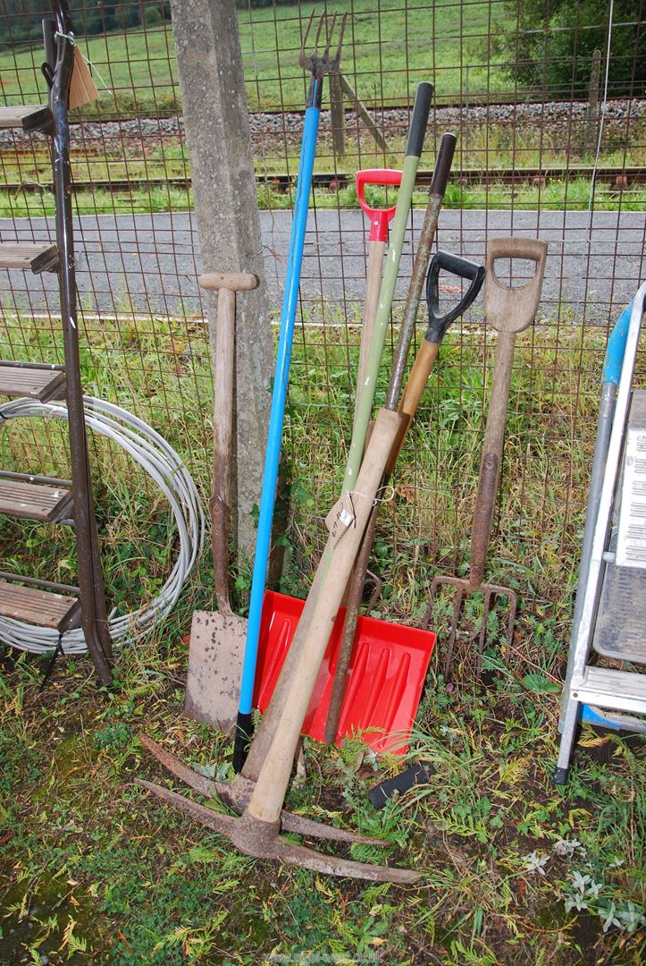 Two pick axes, snow shovel, spade and fork.